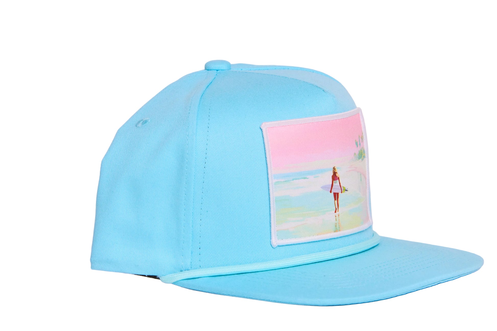 Baby blue flat bill hat with a timeless scene of a woman walking along a beach whilst carrying a surfboard