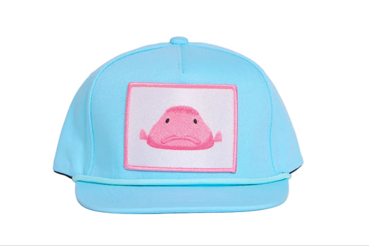 Baby blue flat-bill hat with a pink blobfish patch