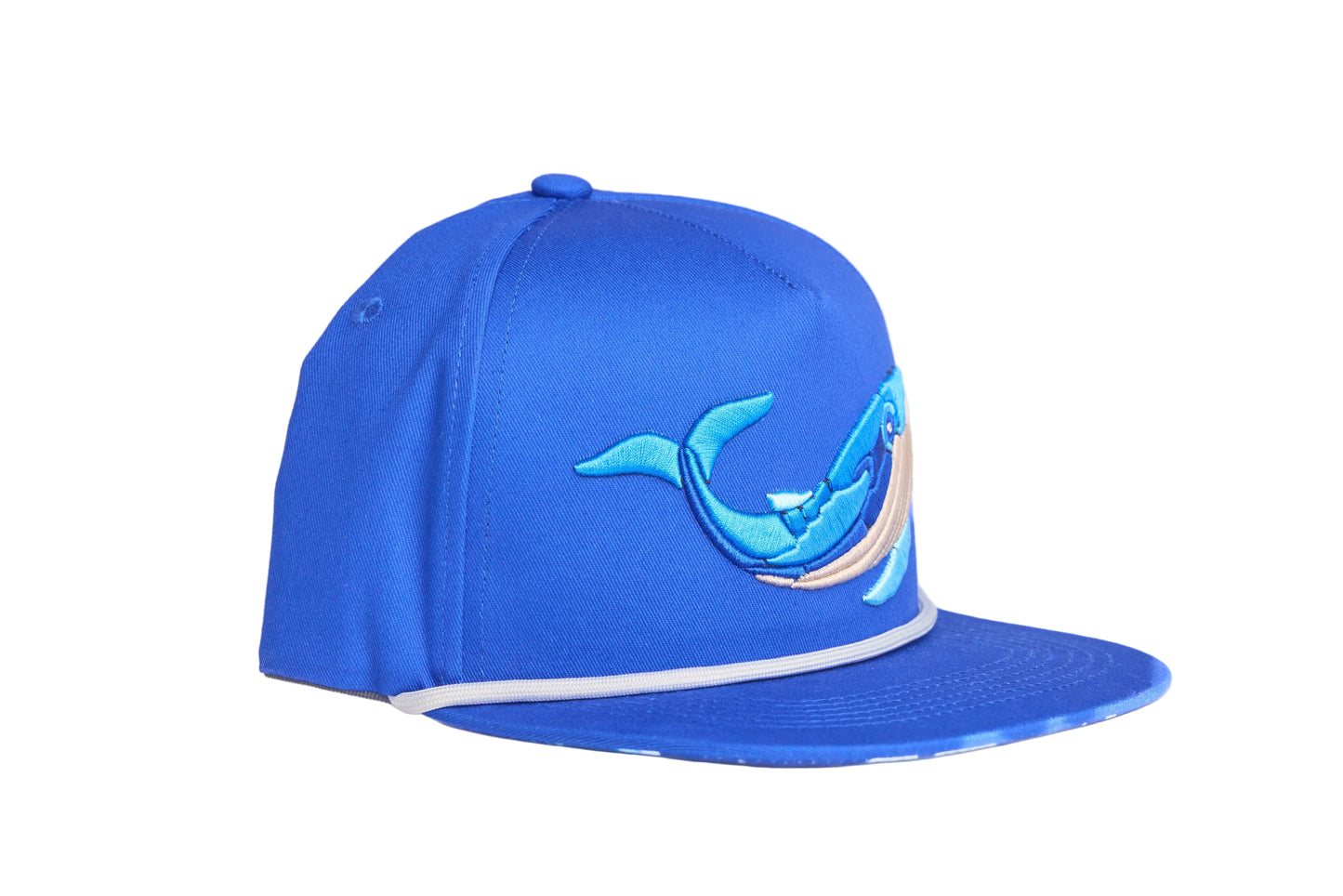 Blue flat-bill hat with embroidered blue whale design and a breaking wave design on the underside of the bill