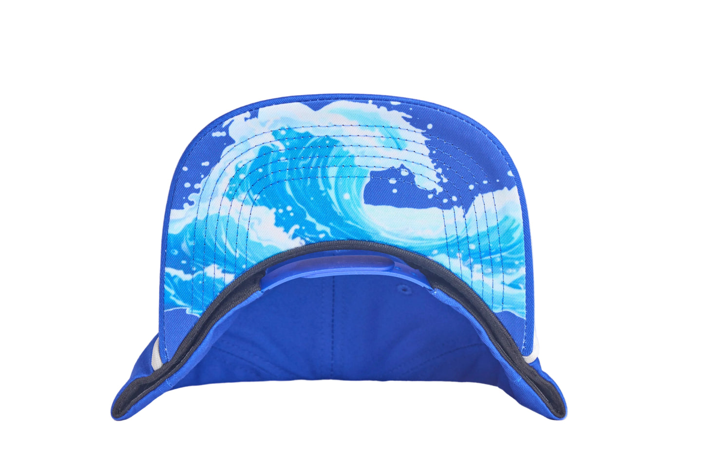 Blue flat-bill hat with embroidered blue whale design and a breaking wave design on the underside of the bill