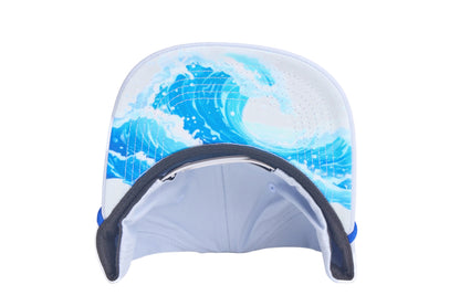 Light grey flat-bill hat with embroidered blue whale design and a breaking wave design on the underside of the bill