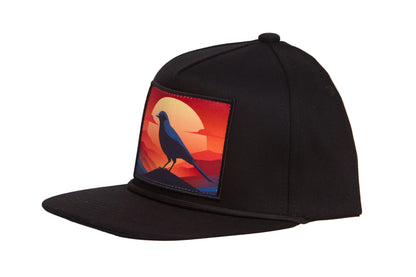 Black hat with a patch of a crow at sunset