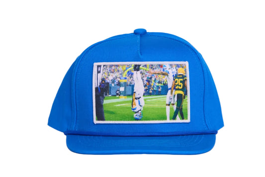 A Honolulu Blue hat featuring the iconic headstand celebration by Amon-Ra St. Brown
