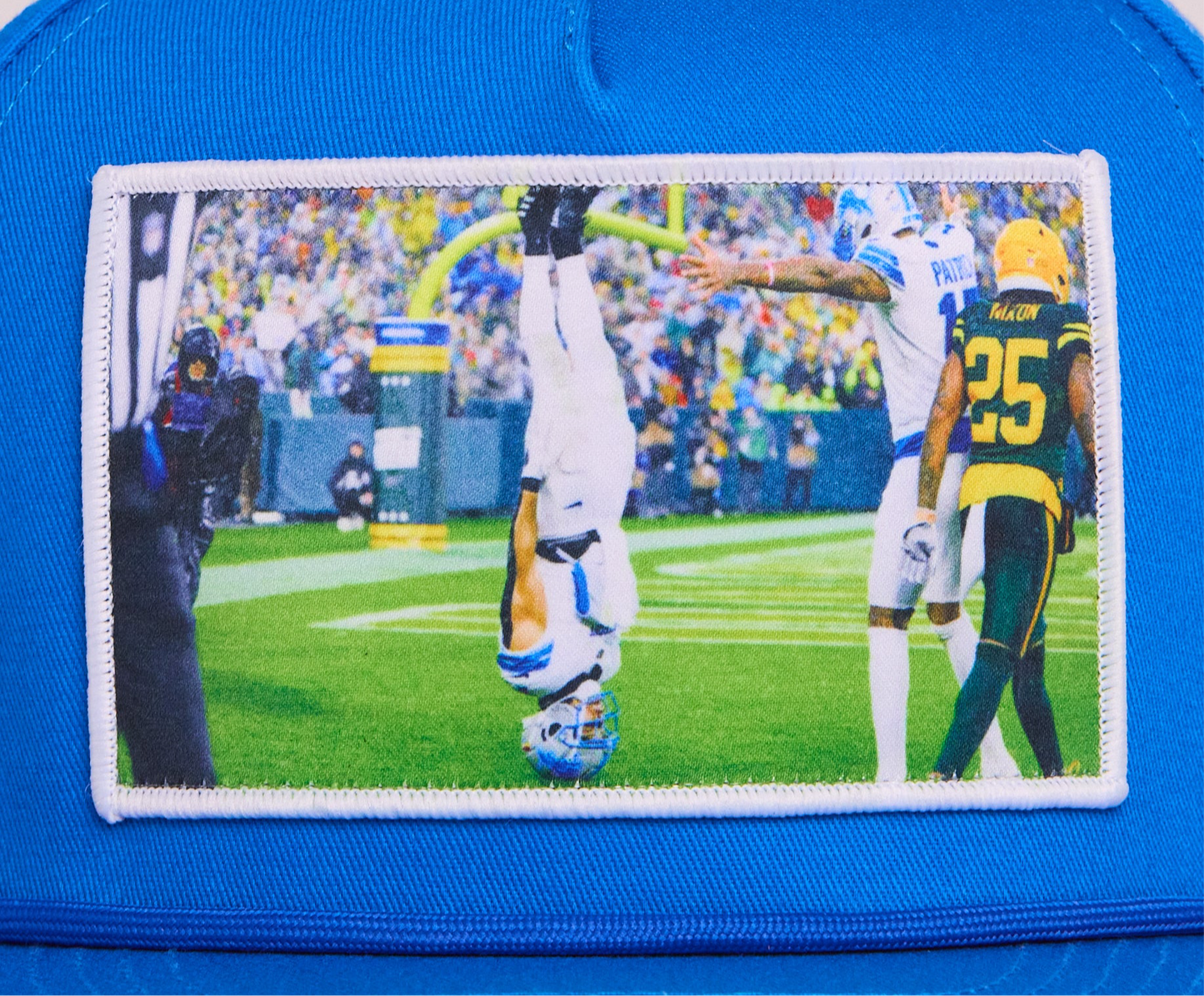 A Honolulu Blue hat featuring the iconic headstand celebration by Amon-Ra St. Brown