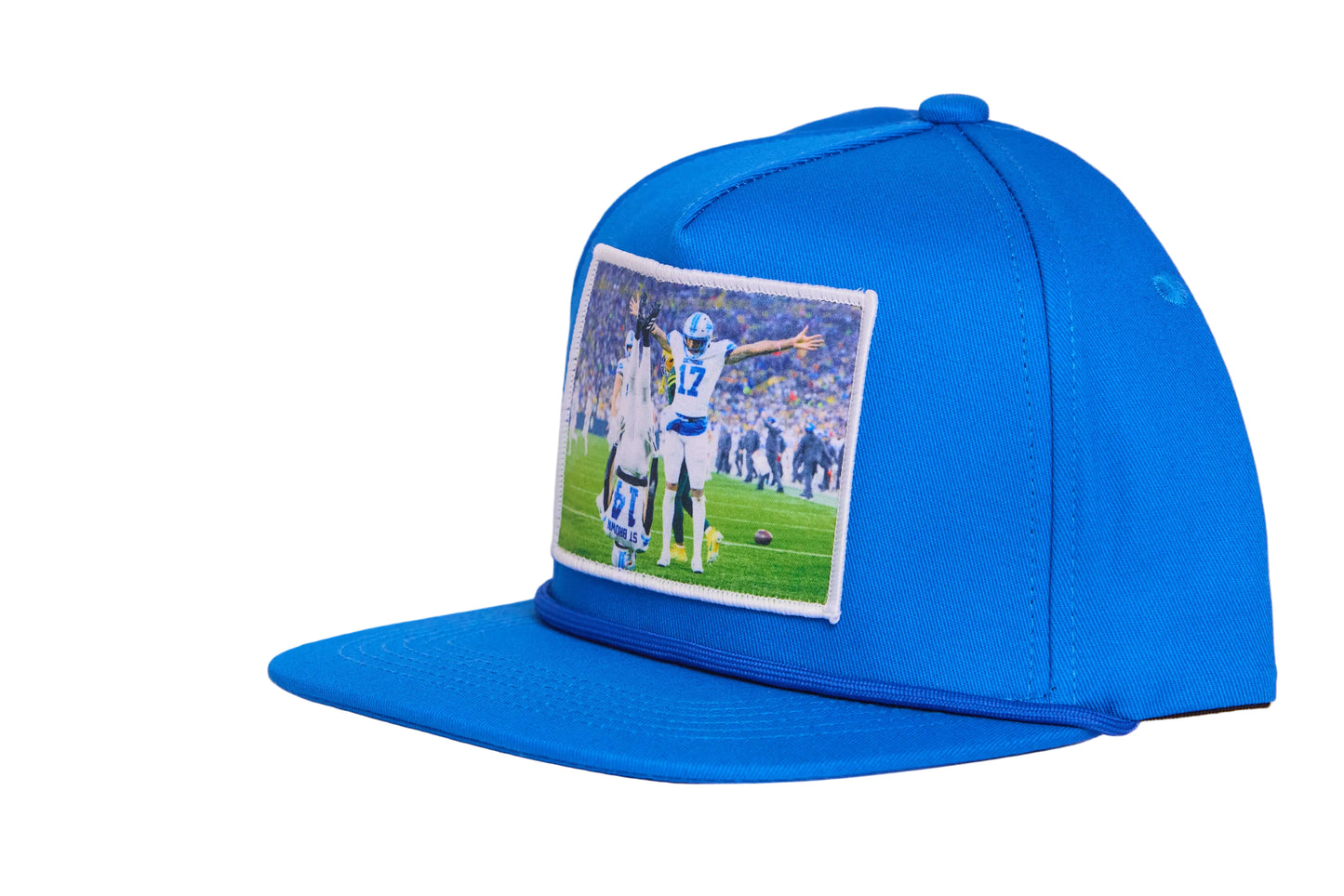 A Honolulu Blue hat featuring the iconic headstand celeration by Amon-Ra St. Brown