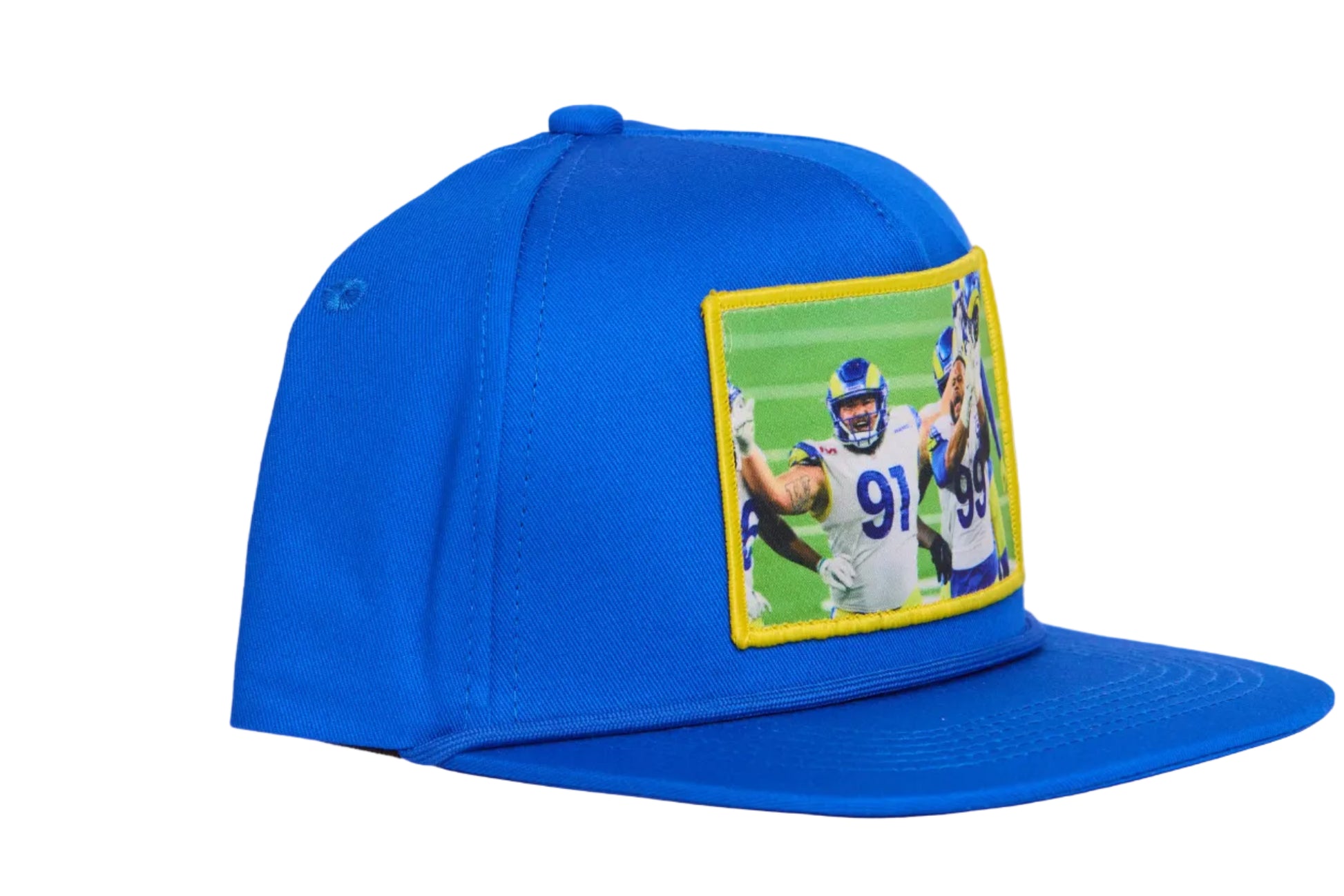 A blue hat featuring a photographic patch of Aaron Donald and Greg Gaines celebrating their Super Bowl win. 