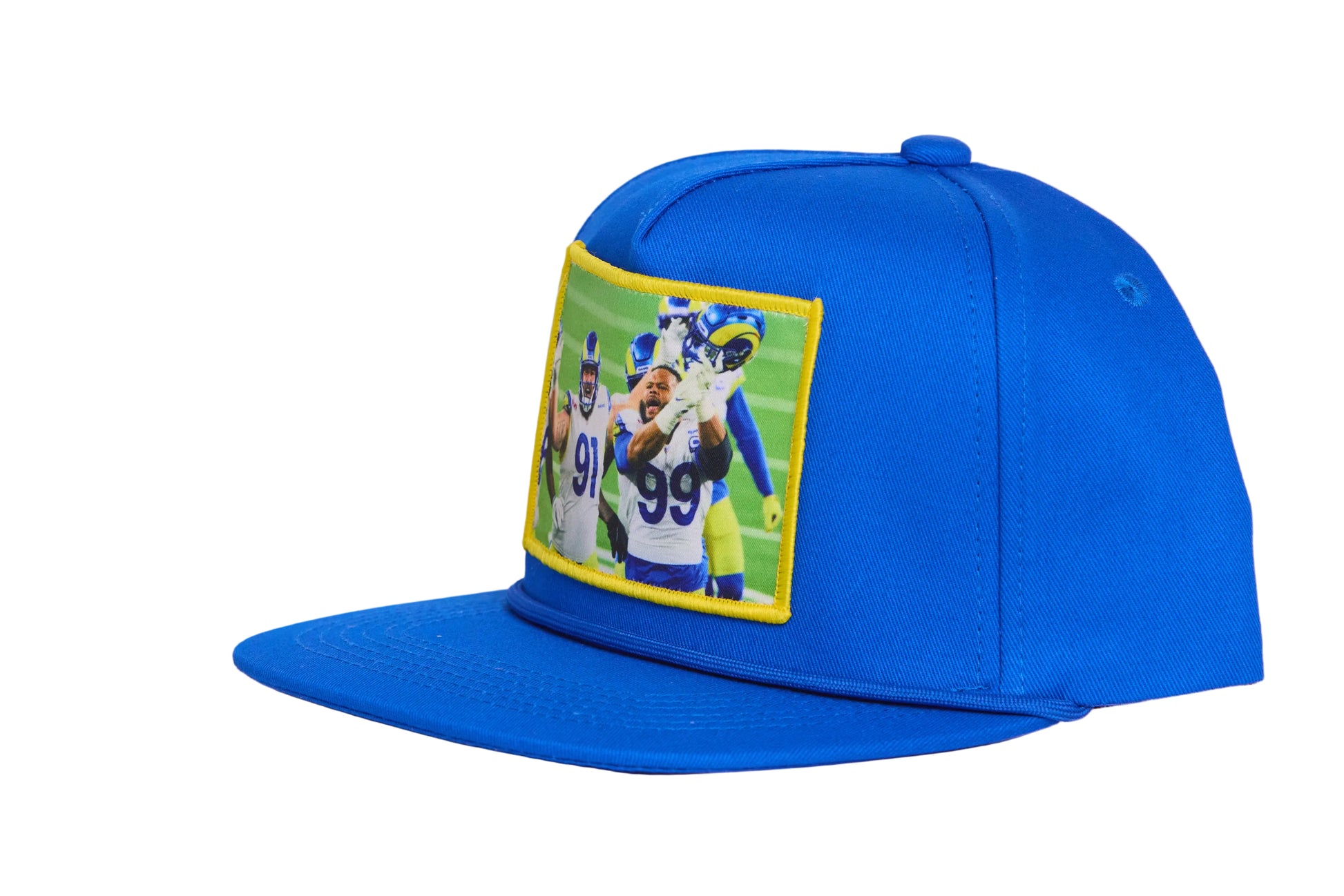 A blue hat featuring a photographic patch of Aaron Donald and Greg Gaines celebrating their Super Bowl win. 