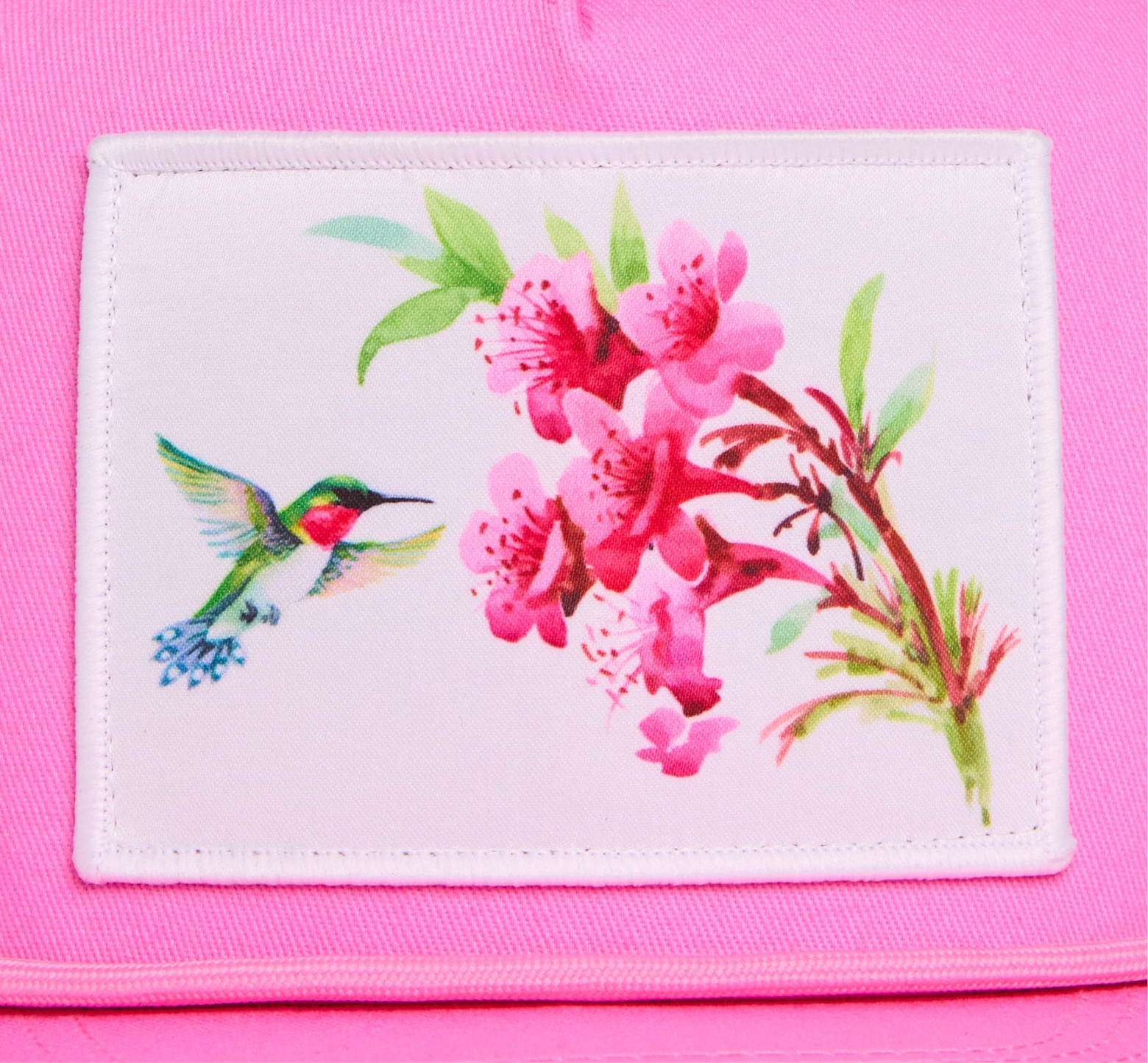 Pink hat with a patch of a hummingbird and flowers