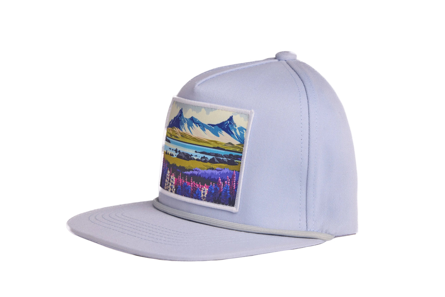 Grey flat-billed hat with a scenic patch featuring mountains and flowers from the southern coast of Iceland