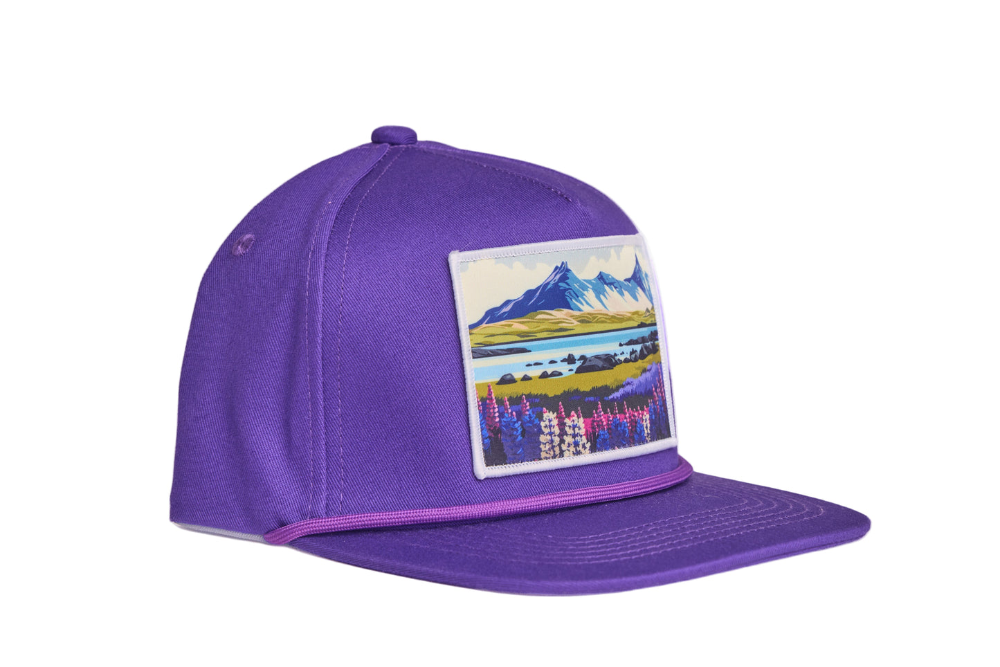 Purple flat-billed hat with a scenic patch featuring mountains and flowers from the southern coast of Iceland