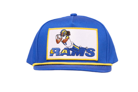 Blue cap depicting Puka Nacua diving for a football for Los Angeles