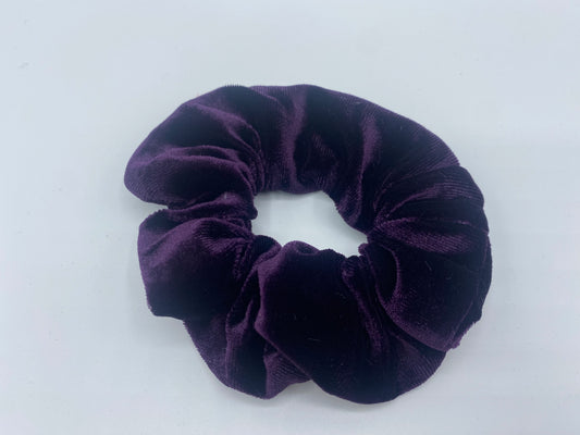  A purple velvet scrunchie with a soft, plush texture, featuring a hidden pocket for discreet storage of small items.