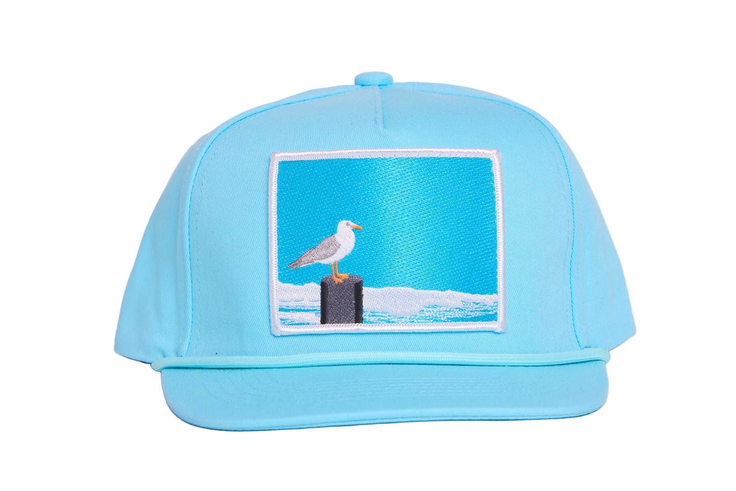 Turquioise ball cap with a light blue embroidered patch featuring a seagull design