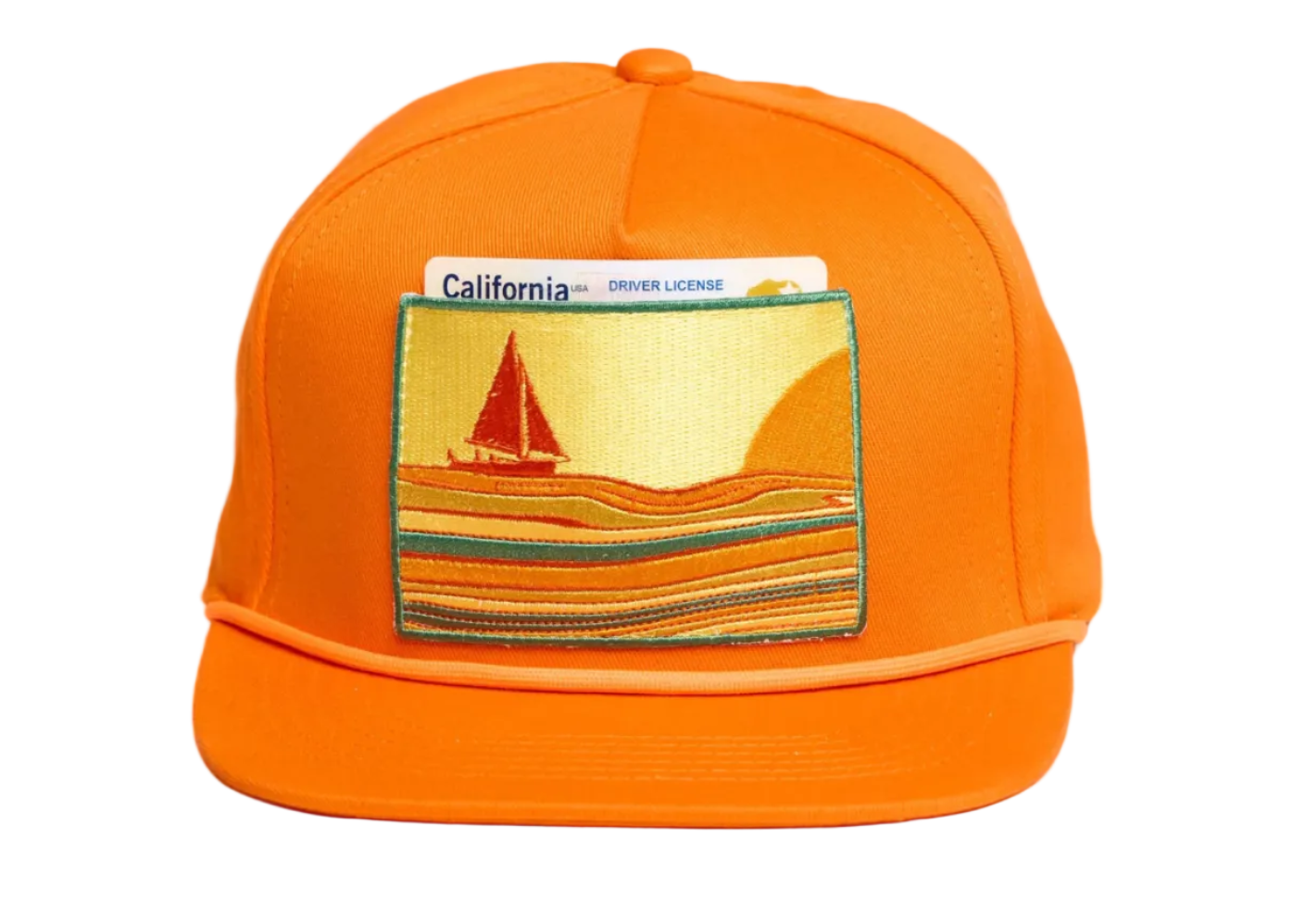 Bright orange snapback cap featuring a rectangular embroidered patch on the front with a sailboat scene and a California driver license card tucked behind it.