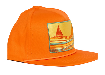 Bright orange baseball cap featuring a rectangular embroidered patch on the front with a sailboat and striped waves in yellow, orange, and teal.
