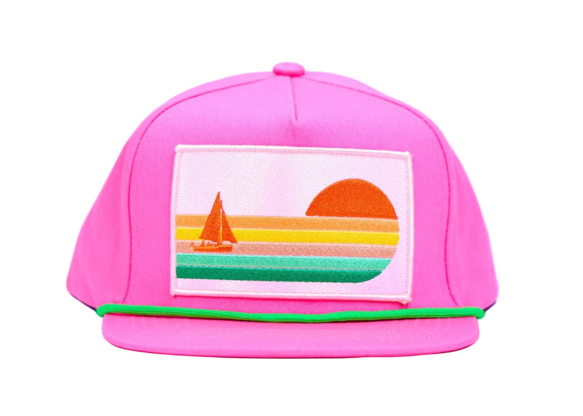 A bright pink baseball cap with a colorful embroidered patch on the front depicting a sunset and sailboat, set against a light blue background.