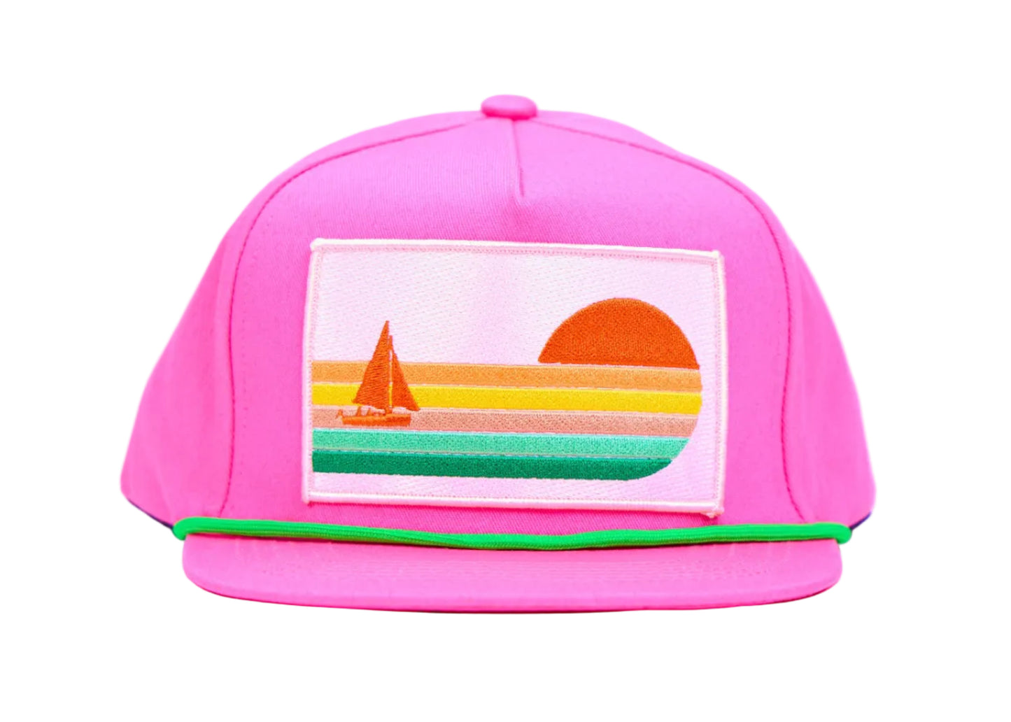 A bright pink baseball cap with a colorful embroidered patch on the front depicting a sunset and sailboat, set against a light blue background.