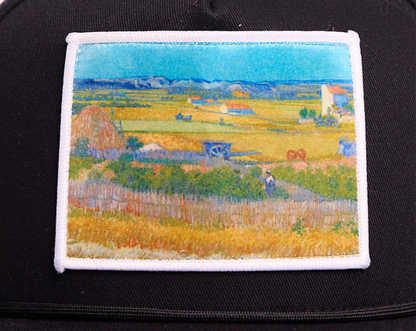 Black flat bill hat with an image of Van Gogh's painting The Harvest