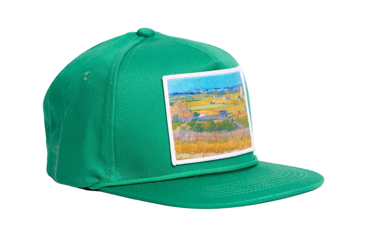 Green flat bill hat with an image of Van Gogh's painting The Harvest