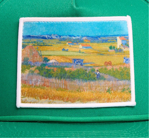 Green flat bill hat with an image of Van Gogh's painting The Harvest