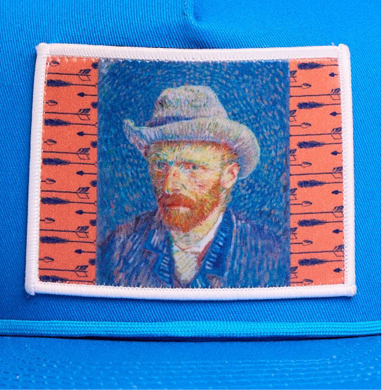Blue flat-bill hat featuring a patch of Vincent Van Gogh's self portrait in grey felt hat